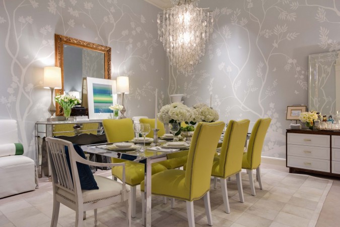 A dining room with yellow chairs and a chandelier, perfect for light and fresh interiors for spring inspiration.