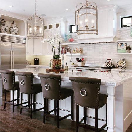 A white kitchen with stylish brown bar stools and a center island.