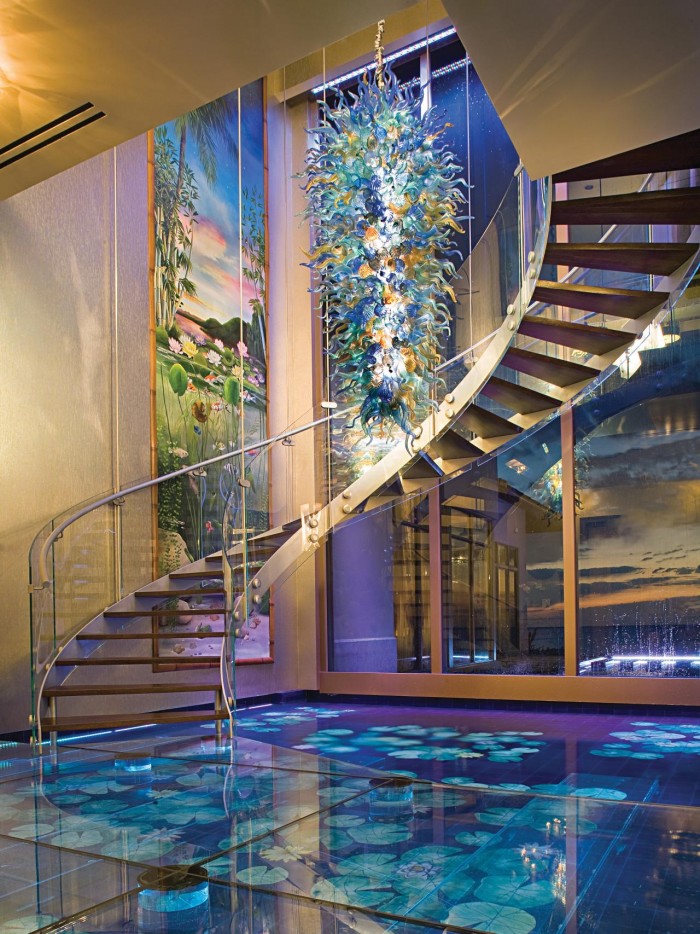 A house with a spiral staircase and a glass floor, incorporating water features for tranquility.
