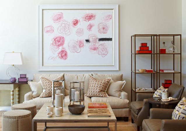 A living room with a large painting on the wall that caters to fashionistas.
