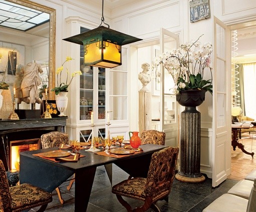 A dining room designed by Jacques Grange with chairs and a fireplace.