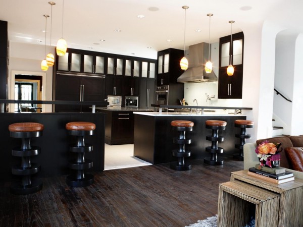 A living room with stylish bar stools in the kitchen.