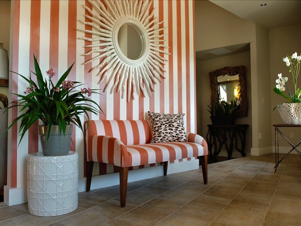 Striped wallpaper with matching settee sets the stage in this foyer 