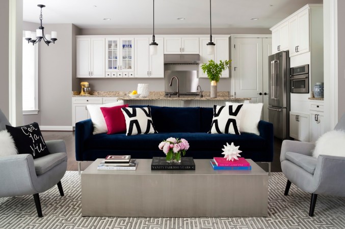 A fashionable living room with a blue couch and white coffee table.