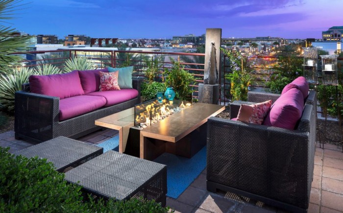 A backyard rooftop patio with purple couches and a fire pit that heats up your landscape.