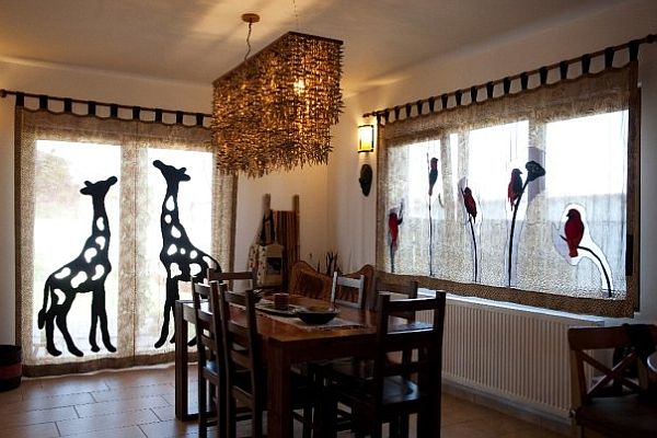 A dining room with unique interior design featuring giraffes hanging from the ceiling.