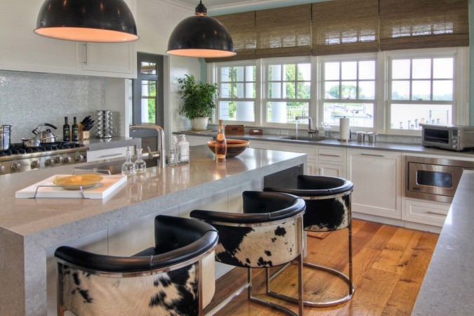 A kitchen with a large island and stylish bar stools.