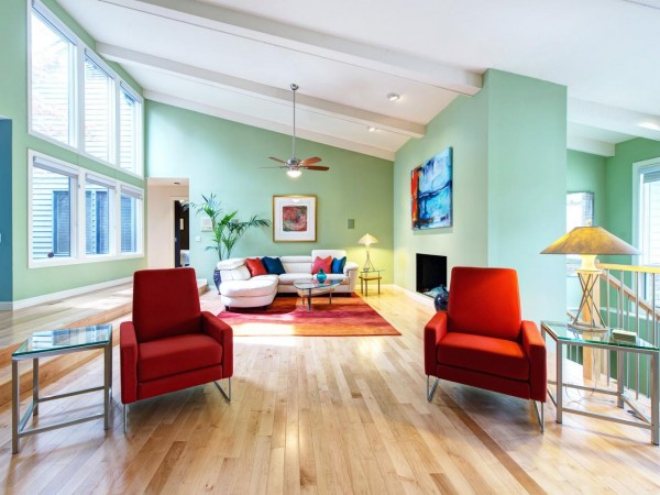 A living room with fresh green walls and vibrant red chairs.