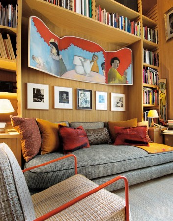 A designer couch in a room with bookshelves.