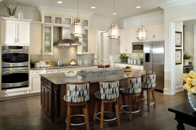 A kitchen with a center island and 18 stylish bar stools.
