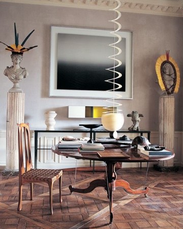 A room with a designer focus on Jacques Grange featuring a table, chairs, and chandelier.