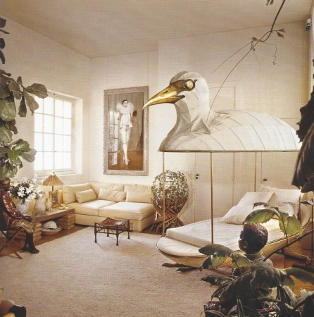 A living room with a bird hanging from the ceiling, emphasizing Jacques Grange's designer focus.