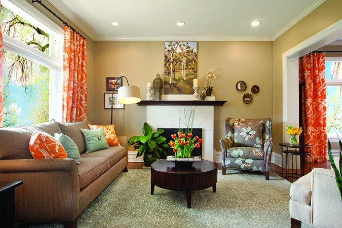 A living room with fresh orange curtains and a fireplace, perfect for spring inspiration.