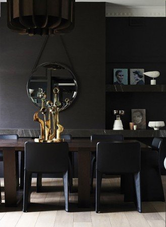 Dark dining room with black walls and furniture.