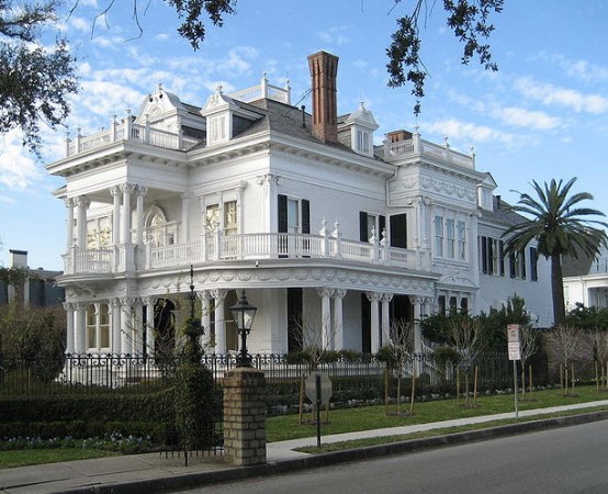 A white victorian house with a tribute to New Orleans on Mardi Gras.
