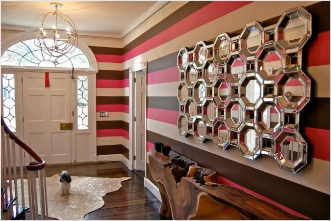 A stunning foyer with striped walls and mirrors.