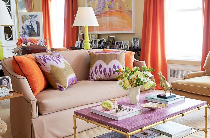 A vibrant living room with orange curtains and a coffee table, creating a spring-inspired interior.