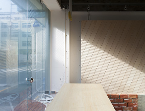 A room with a wooden table and a window designed to create motion through lines.