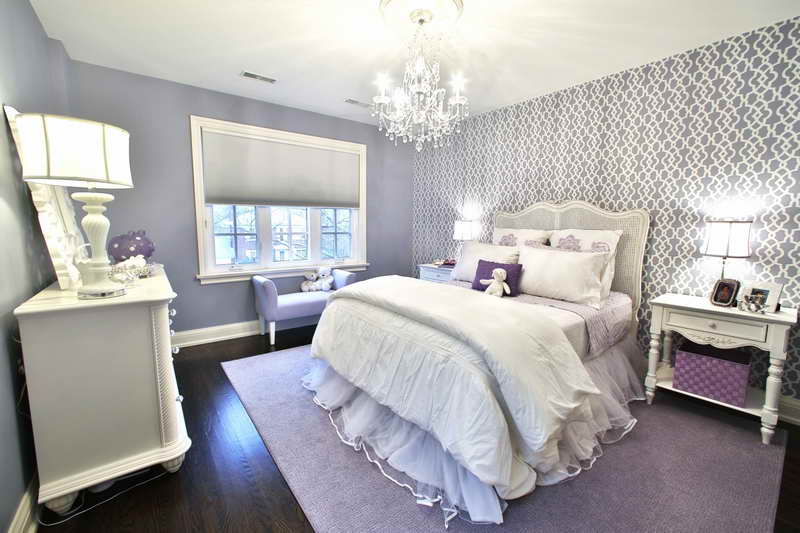 A purple and white bedroom with a chandelier designed for the picky teenager.