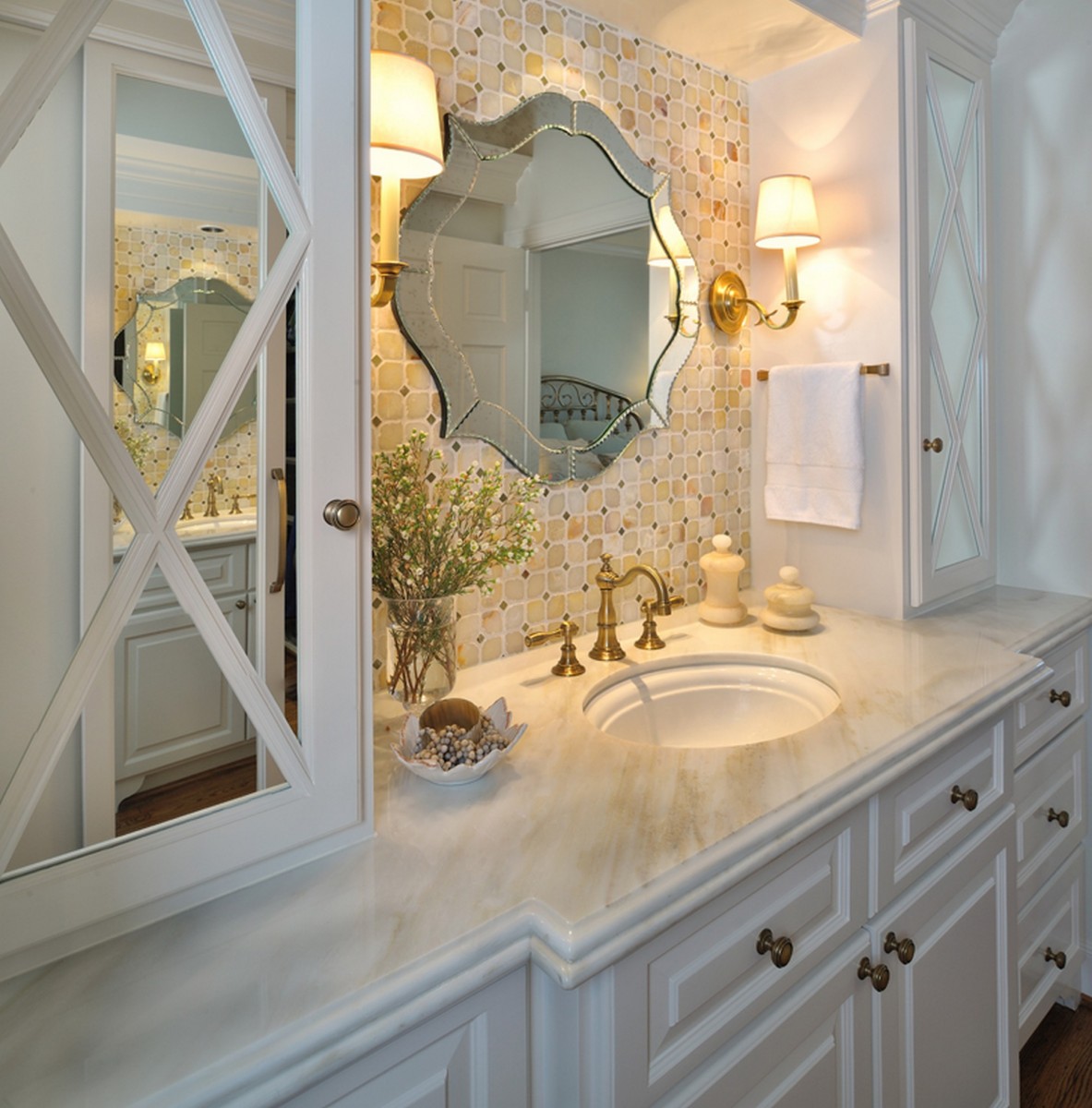 A bathroom with unique mirrors and white cabinets.