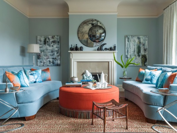 A living room with blue couches, orange accents, and spring interior.
