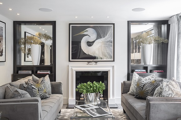 A sophisticated living room with grey couches and a fireplace designed for the modern woman.