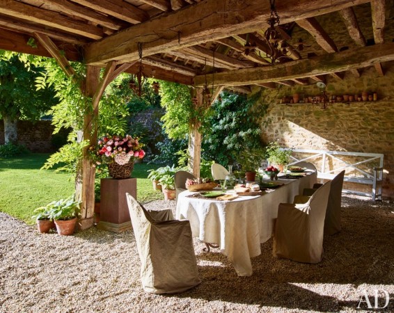 An outdoor dining area with a table and chairs, where you can travel to Tuscany from your backyard.