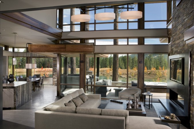 A modern living room with large windows and a fireplace.