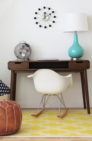 A Mid-Century Modern Home Office with a desk, lamp, and clock.