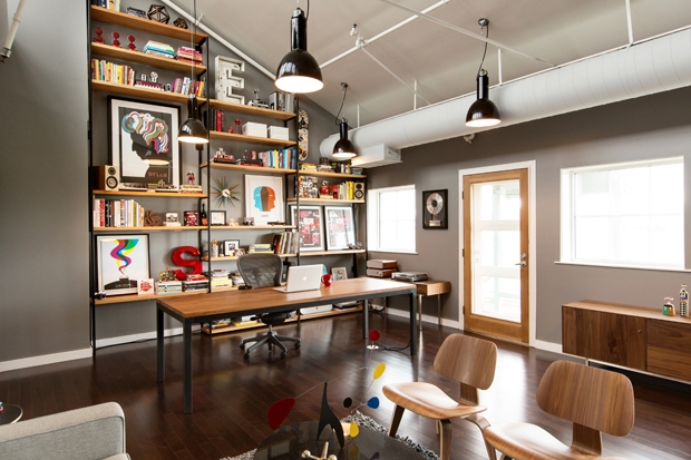 A home office with lots of bookshelves and a desk, designed in the Industrial Style.
