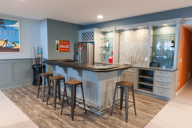 A home bar with stools that provides 10 creative uses for the basement.