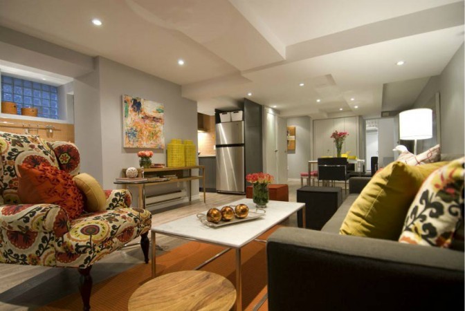 A living room with colorful furniture and a coffee table offers creative uses for the basement.