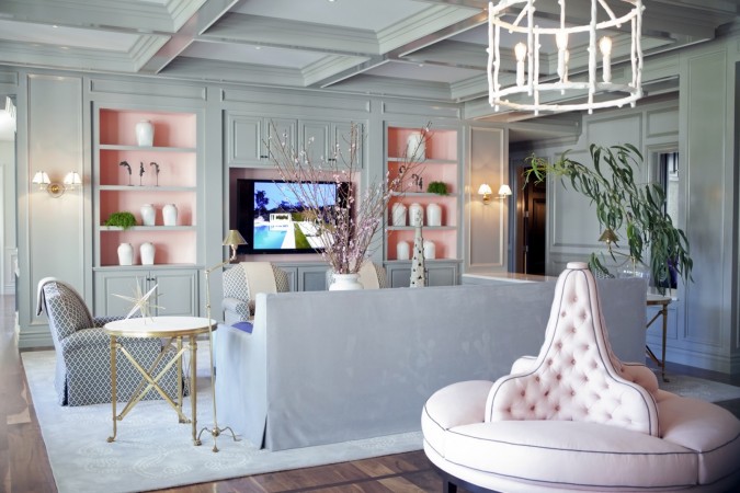 A living room with refined luxury featuring pink furniture and a tv.
