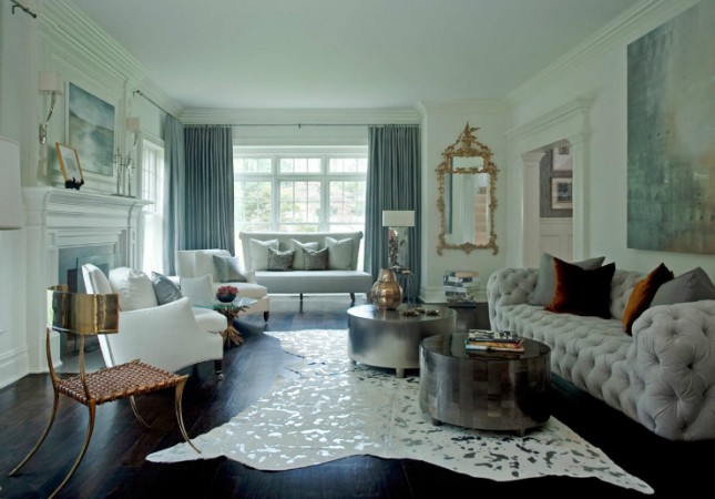 A living room with sophisticated and feminine white furniture and a cowhide rug, perfect for the modern woman.