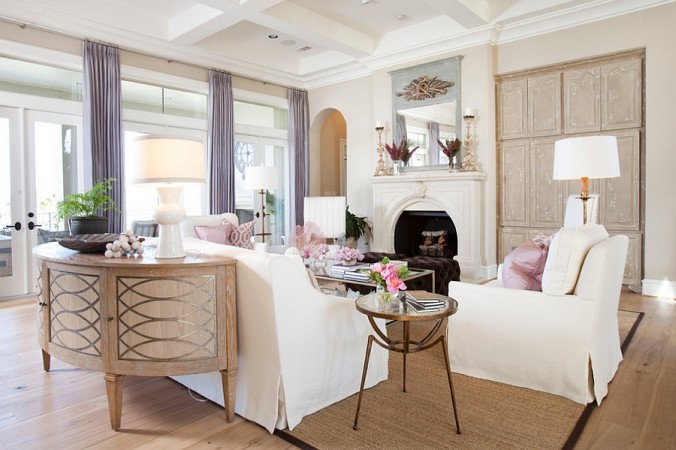 A sophisticated living room with white furniture and a fireplace, designed for the modern woman.