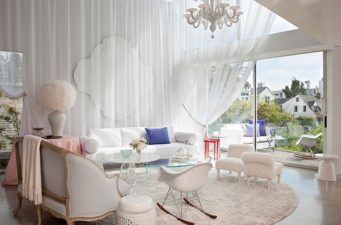 A sophisticated living room with white furniture and a chandelier, perfect for the modern woman.