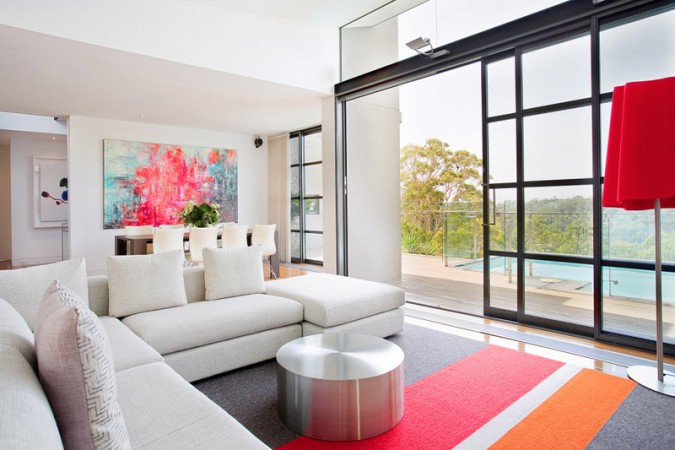 A living room with sophisticated and modern interiors, featuring a fireplace and sliding glass doors.