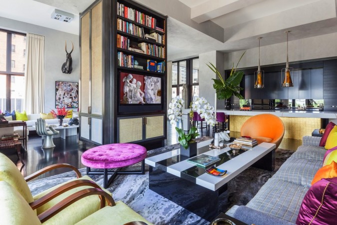 A living room with colorful furniture and bookshelves designed for the modern woman.