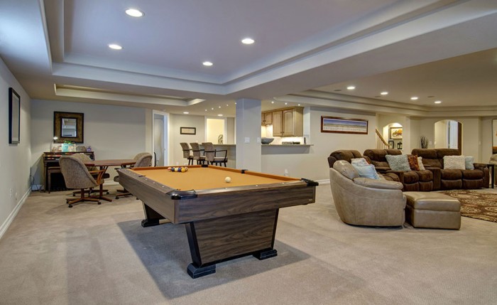 A basement with a pool table and couches is one of the 10 creative uses for the basement.