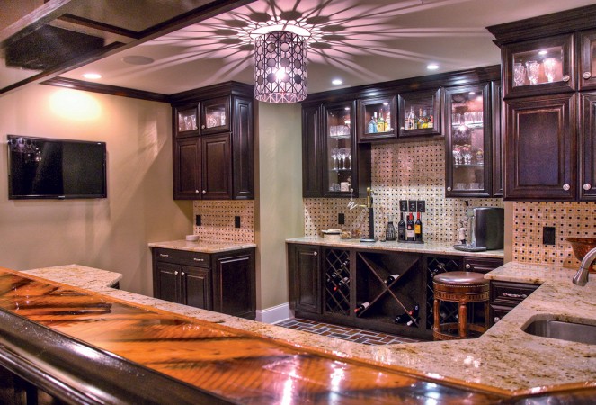 A kitchen with a bar counter and cabinets transformed into 10 Creative Uses for the Basement.