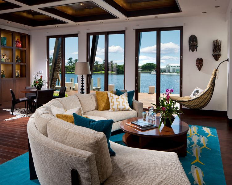 A cozy living room with a view of the water featuring curved sofas.