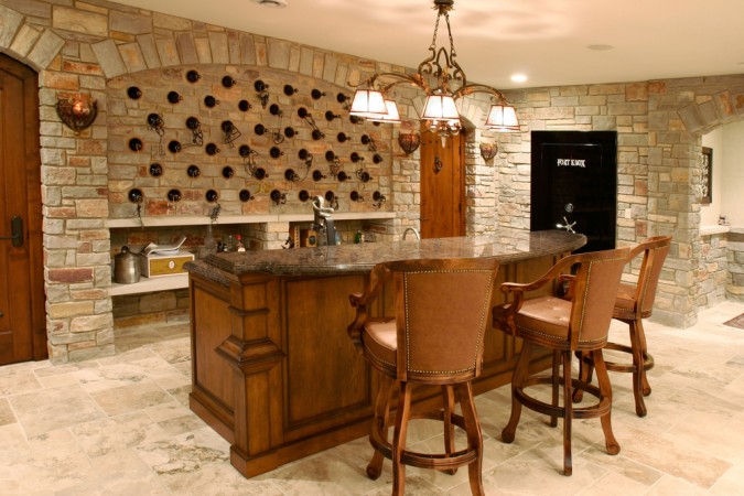 A bar with stools and a wine rack in the basement.