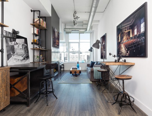 A living room with industrial-style bar stools and a picture on the wall.