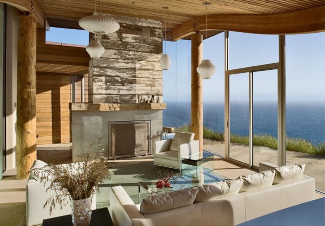 A modern living room with a view of the ocean in The Wood and Stone Modern Home.