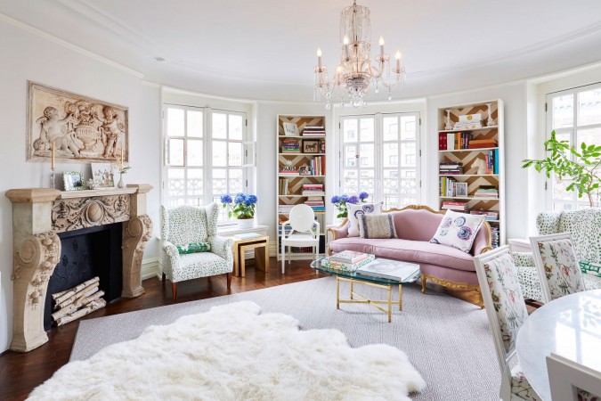 A living room with white furniture and a pink fur rug, designed for the modern woman seeking sophisticated femininity.