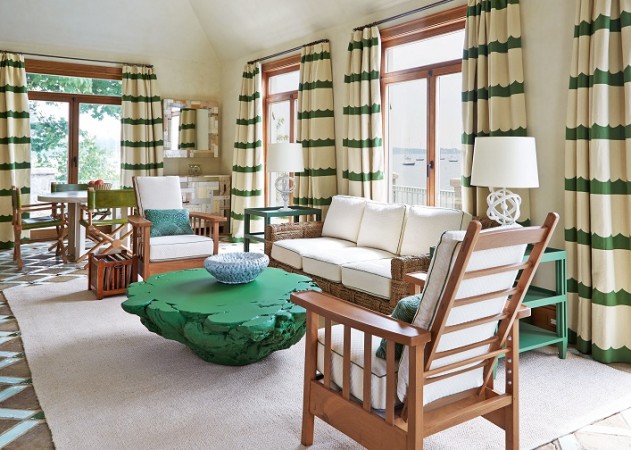A sophisticated living room with green and white striped curtains.