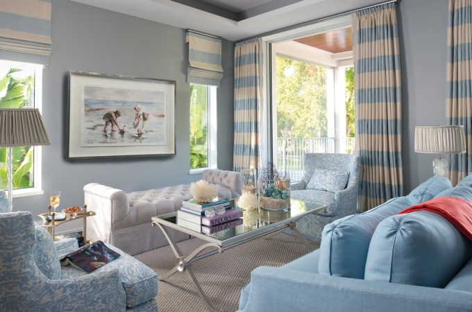 A living room with sophisticated blue and white striped furniture.