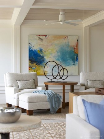 A living room with a large abstract painting on the wall.