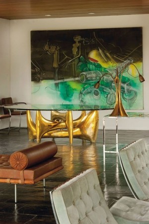 A living room with a large painting on the wall, showcasing Mid-Century Modern Glamour.