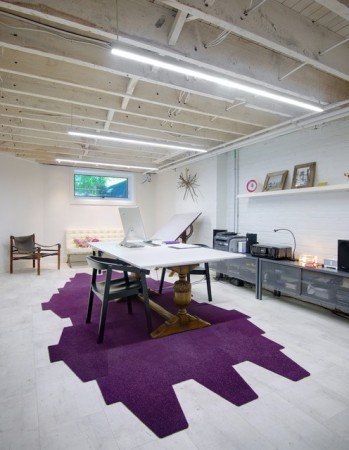 A room with a purple rug and a desk in an Industrial Style Home Office.